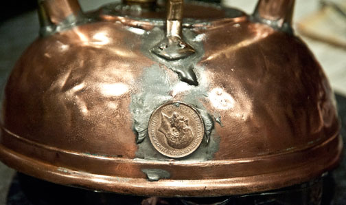 Photo of a penny soldered over the hole where the spout used to be