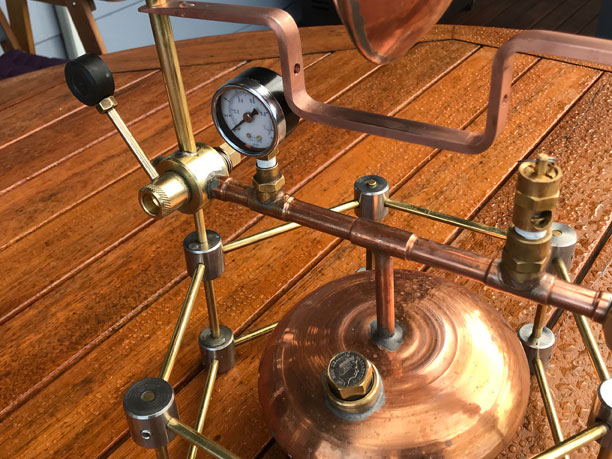 A shiney copper tank in the shape two desert bowls joined together.